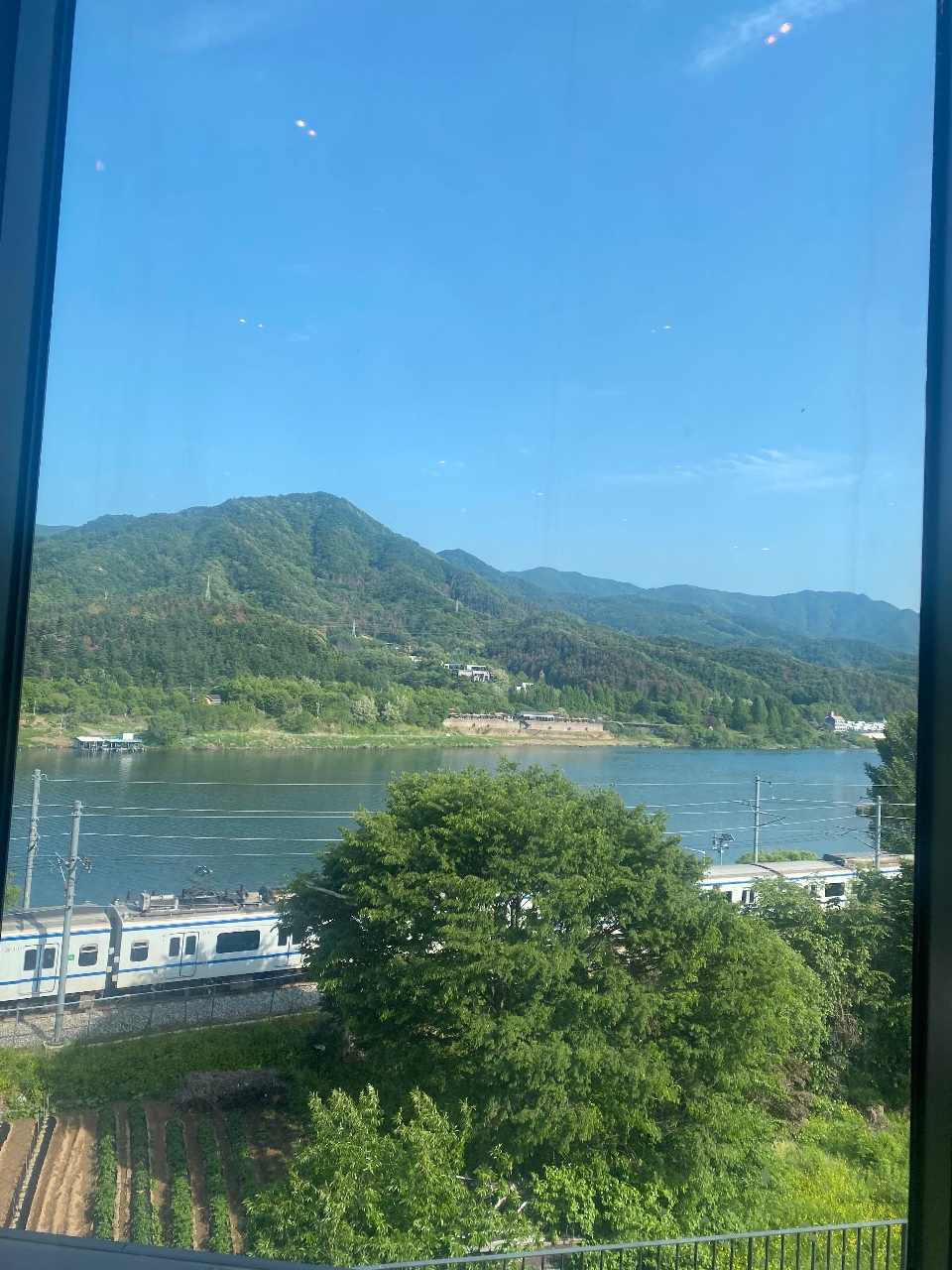 창가에서 본 강변의 산, 나무, 기차역