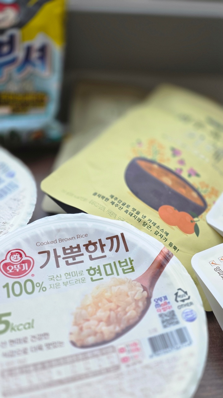 즉석밥 패키지와 반찬이 놓인 식탁