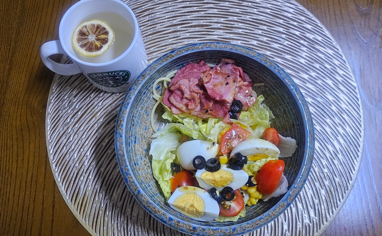 식탁에 차려진 계란, 햄, 채소 샐러드와 레몬차