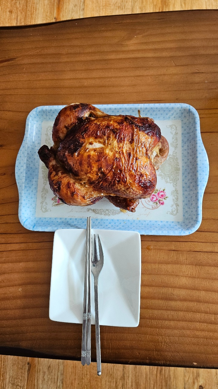식탁에 차려진 구운 닭과 젓가락, 포크
