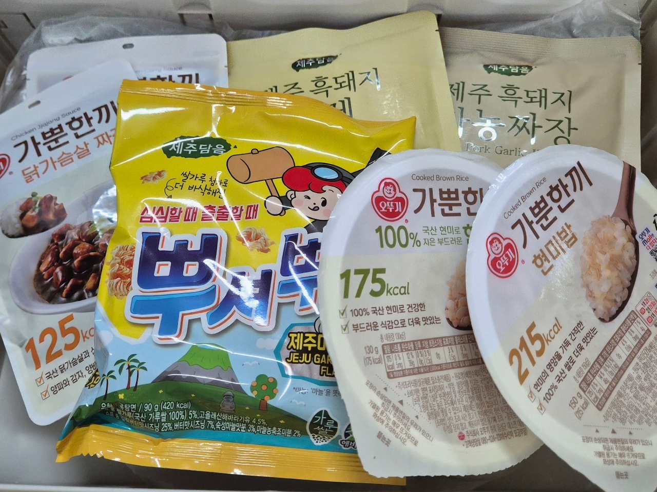 한국 식품 패키지들이 담긴 상자, 스낵·밥·반찬 제품