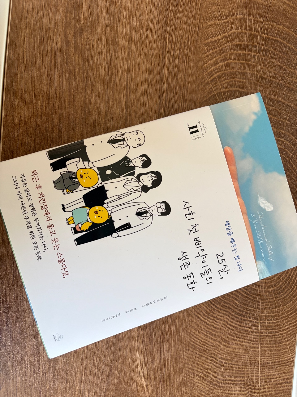 목재 바닥에 놓인 캐릭터 일러스트와 한글 텍스트가 있는 책자