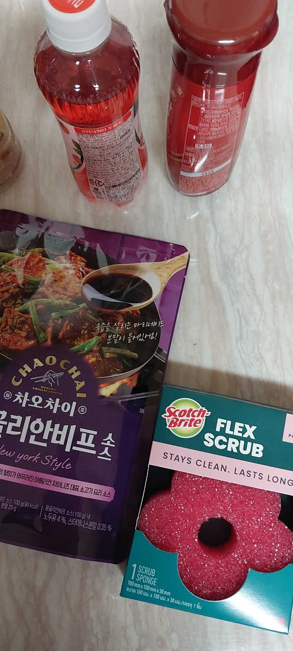 음료수 병과 소스 봉지, 스폰지 세트가 놓인 테이블