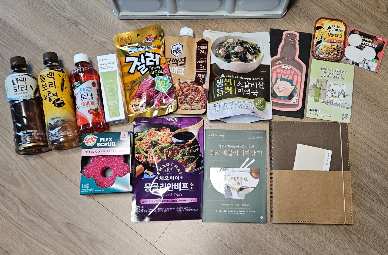 식탁에 펼쳐진 한식 간편식, 음료, 요리책, 스킨케어 제품들