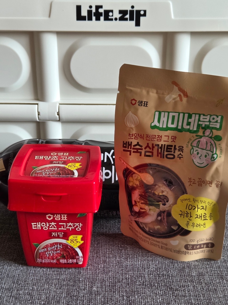 라이프집 로고가 있는 선반 위에 놓인 한국 반찬과 국 제품