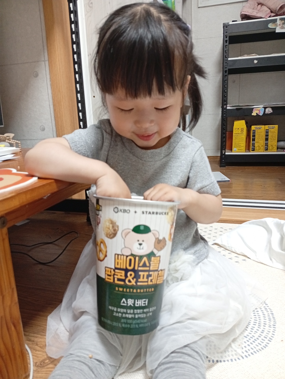 아이가 스낵 과자 통을 들고 있는 모습