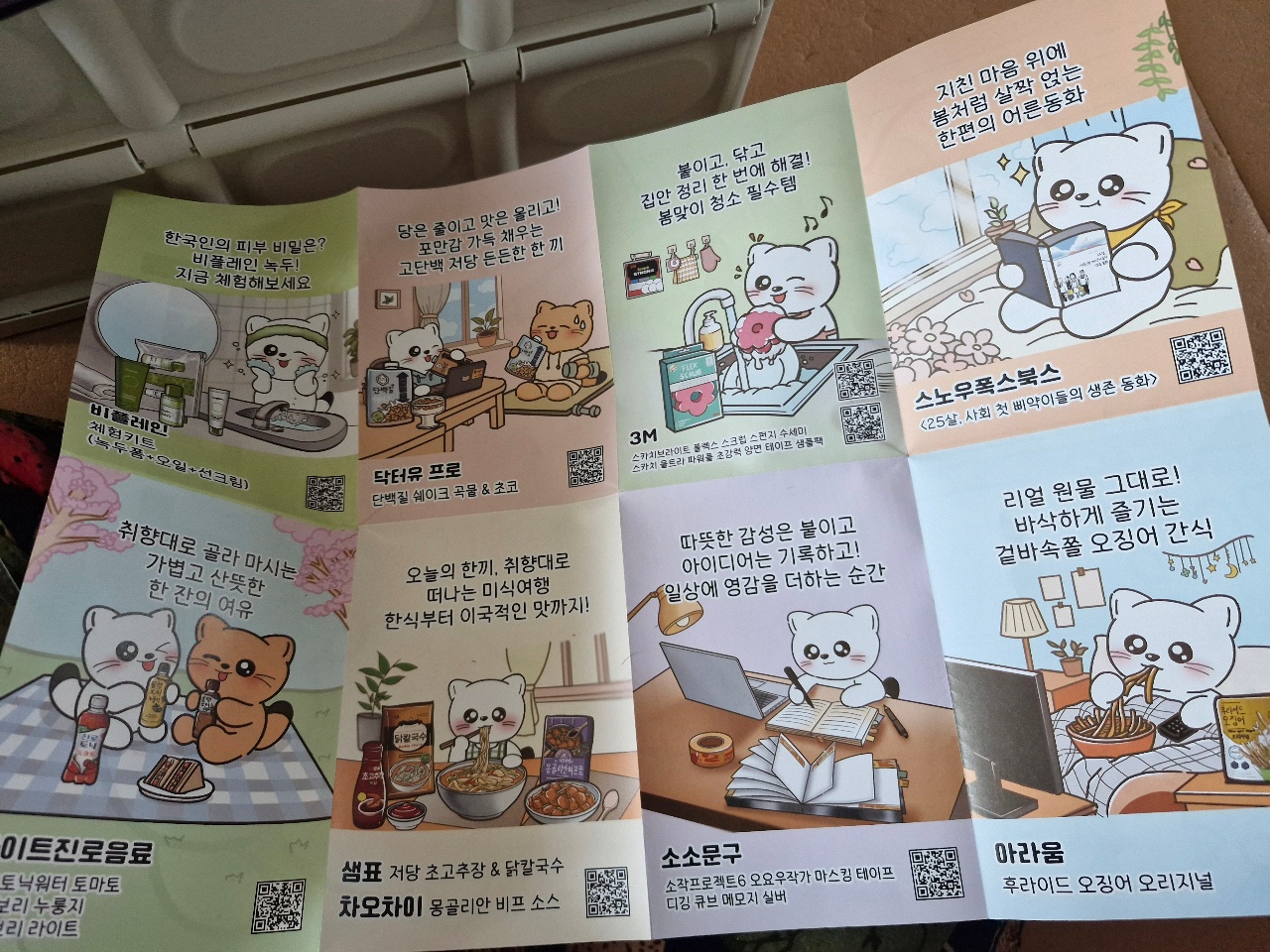 고양이 캐릭터가 그려진 한글 텍스트와 QR코드가 있는 여러 장의 전단지