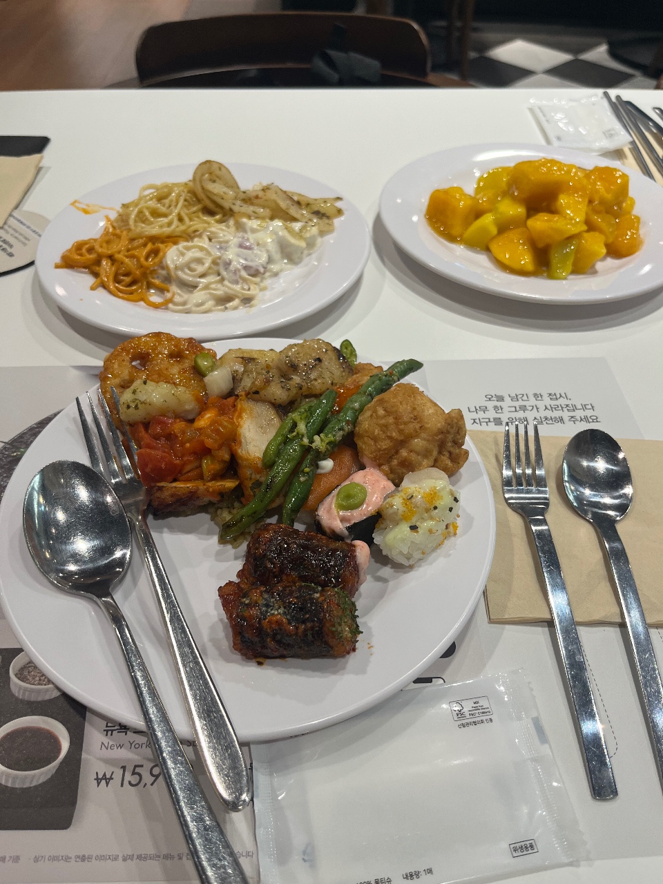 식탁에 차려진 스테이크, 새우, 면 요리와 옥수수 반찬