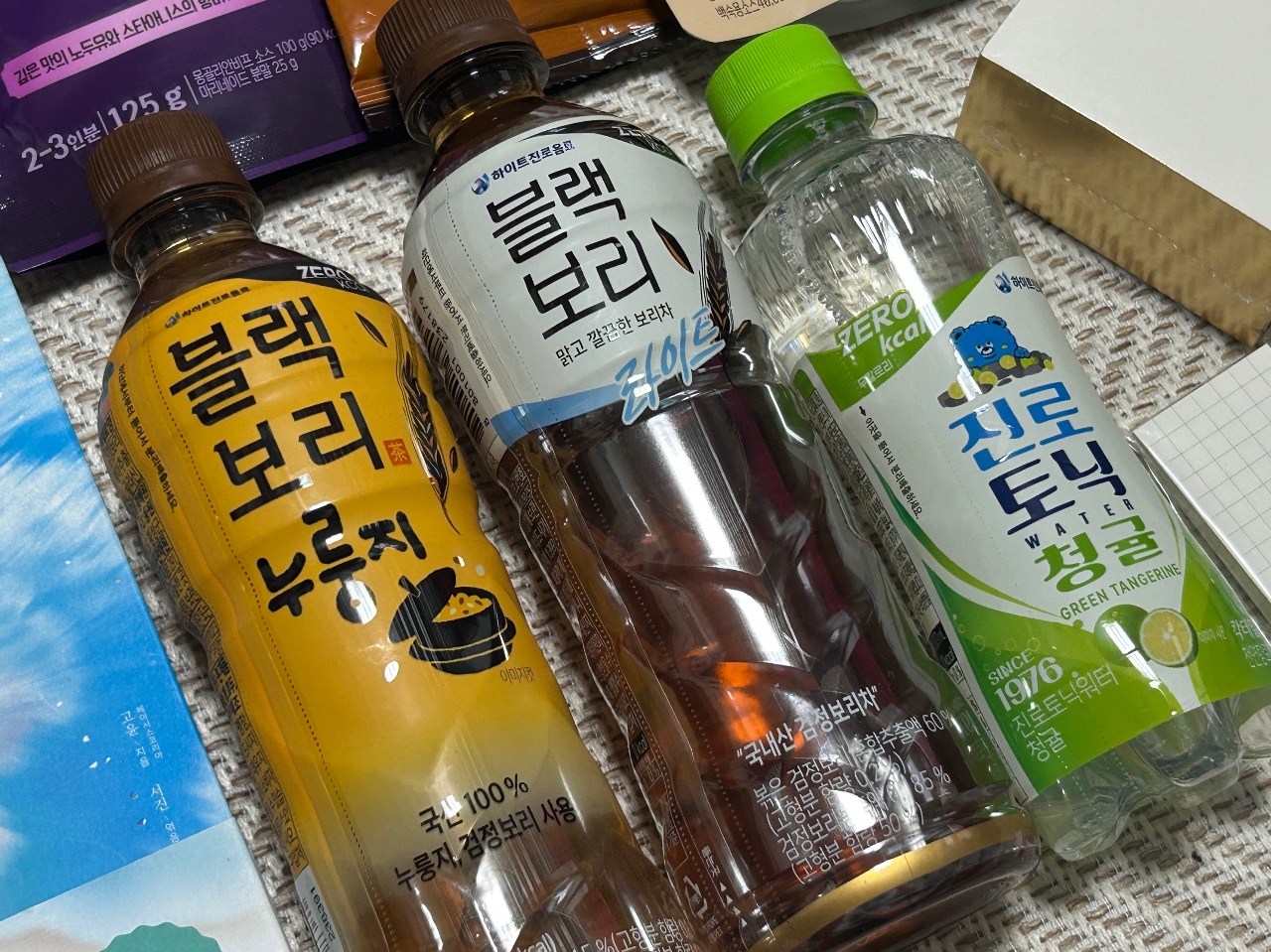 식탁에 놓인 보리차와 물, 음료수 병들