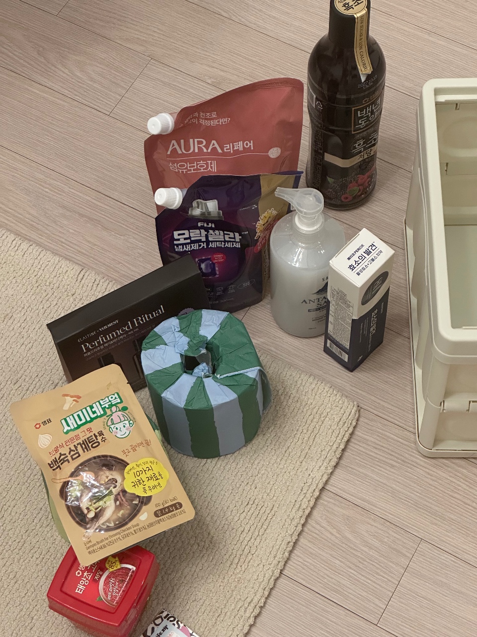 바닥에 펼쳐진 화장품, 간식, 음료, 세제 등의 생활용품