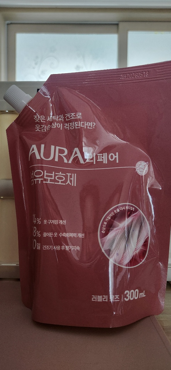 창가 책상 위에 놓인 AURA 브랜드 헹굼제 팩