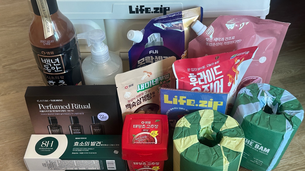 생활용품 정리용 투명 박스에 담긴 화장품, 간식, 세제 등 다양한 소비재