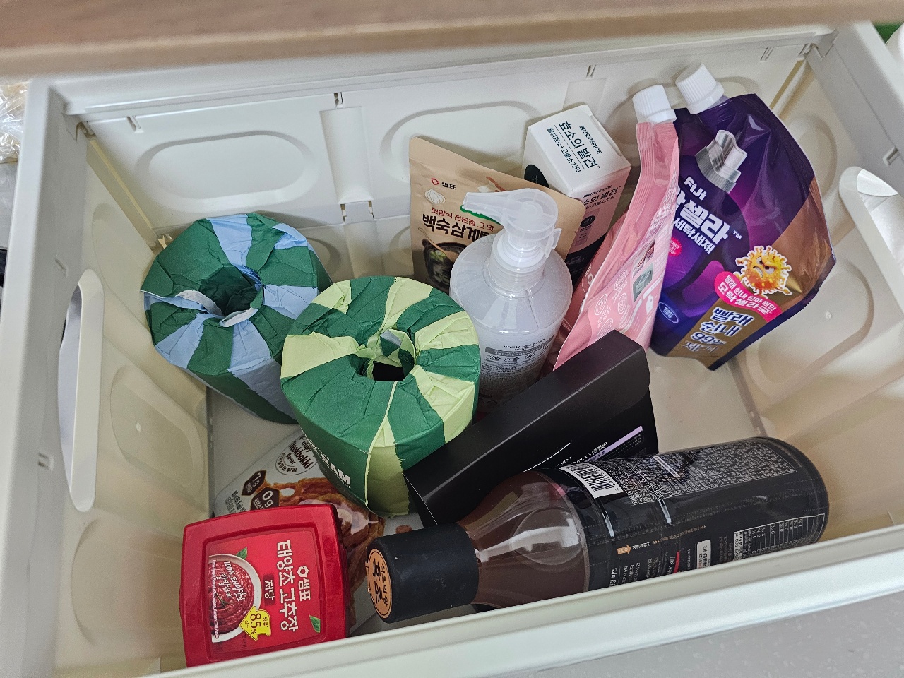 서랍 안에 정리된 세제, 세탁용품, 우산, 생활용품