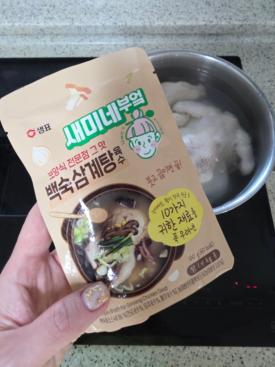 한글 패키지의 닭백숙 국물 제품과 준비된 냄비