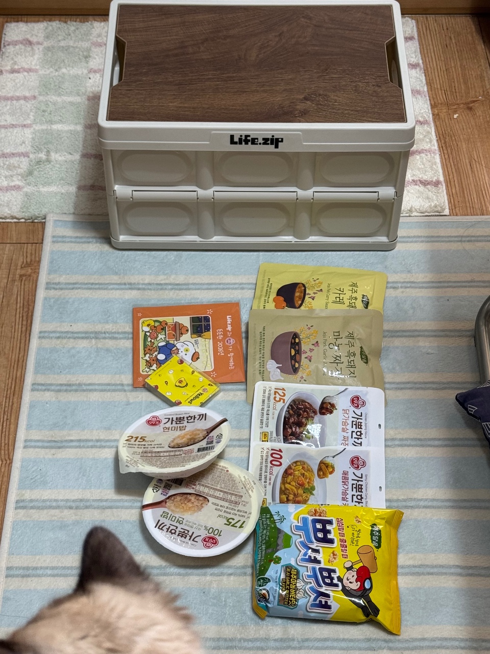 수납함과 식품 패키지, 반찬 사진이 함께 놓인 식료품 모음