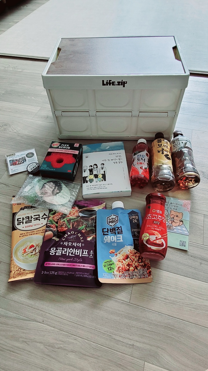 수납함 앞에 펼쳐진 한식 간편식품과 음료, 책