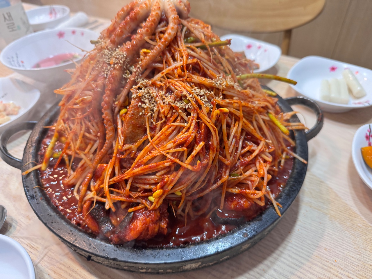 철판에 담긴 낙지, 오징어, 새우 등 해산물 볶음과 곁반찬