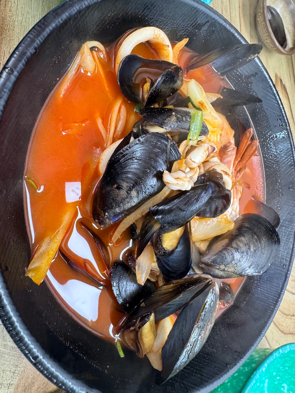 검은 접시에 담긴 홍합과 조개류 해산물 요리