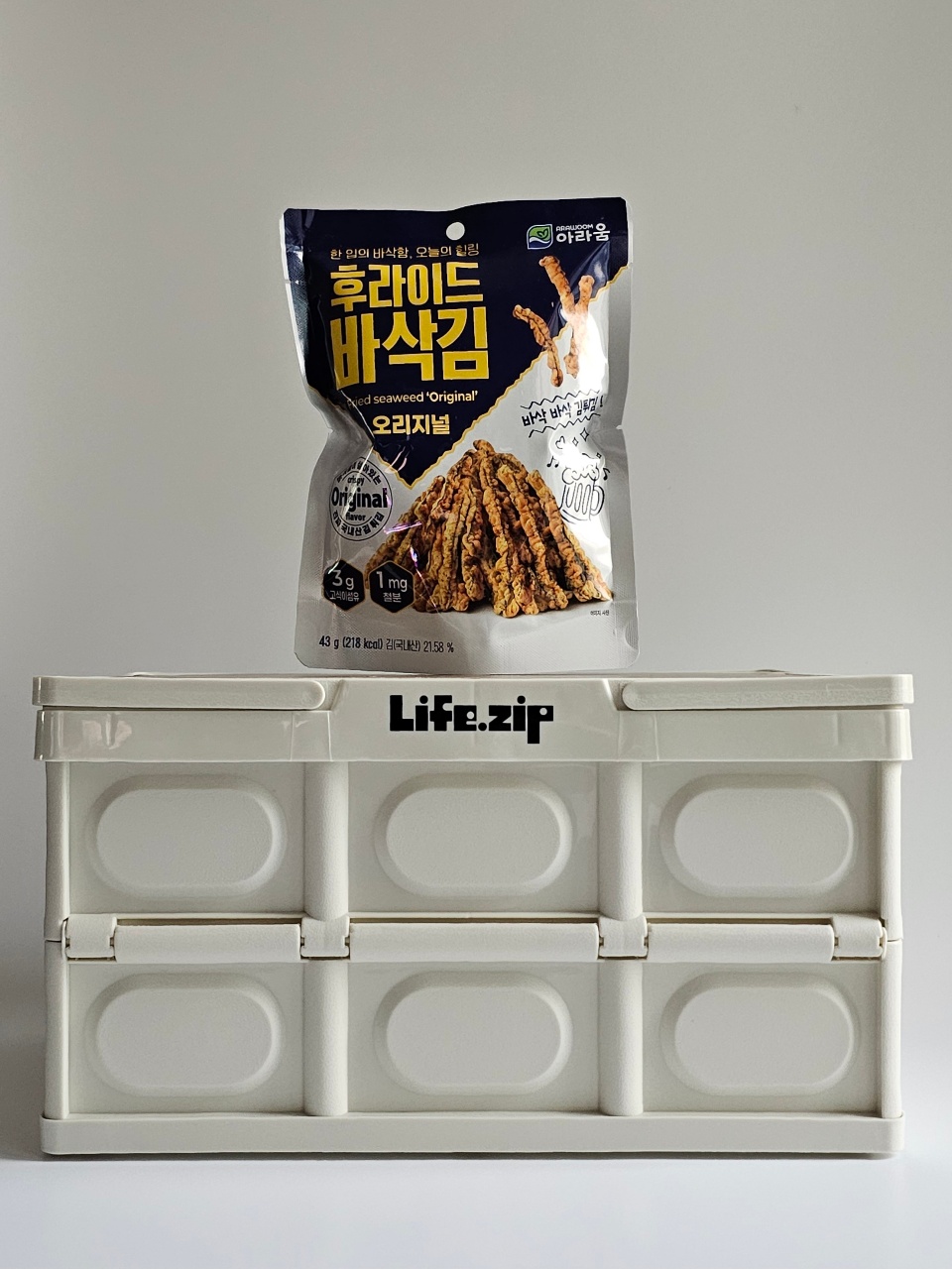 바삭김 한 봉지와 흰색 정리용 수납함