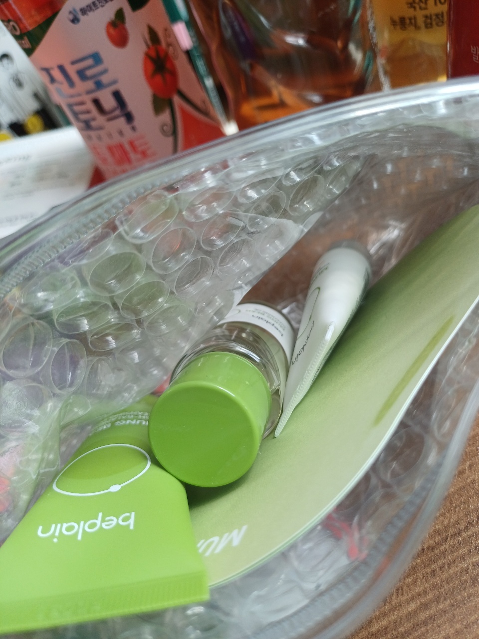 화장품과 음료수 병이 담긴 투명 플라스틱 용기