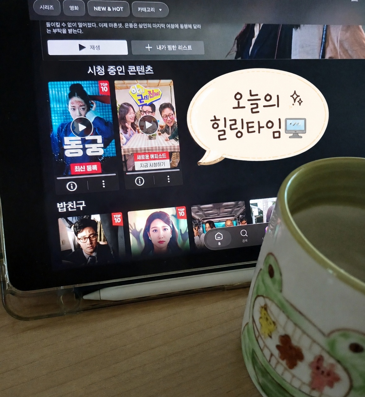 스트리밍 서비스 앱에 표시된 드라마 콘텐츠와 머그잔