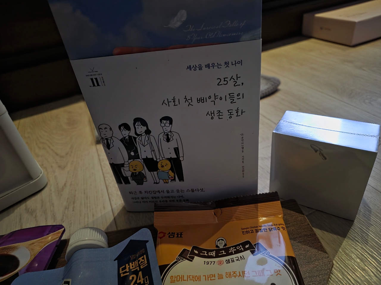 책상 위에 놓인 한국어 책과 소책자, 박스