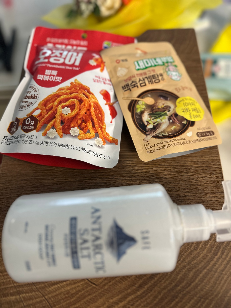 나무 테이블 위에 놓인 한국 간식 포장과 병 제품