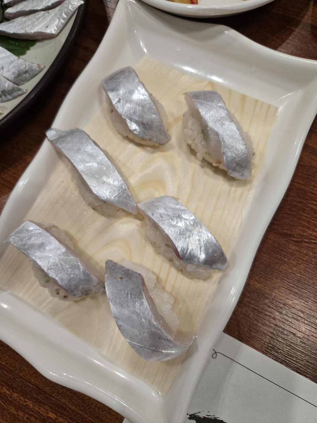 흰 접시에 담긴 생선회 초밥