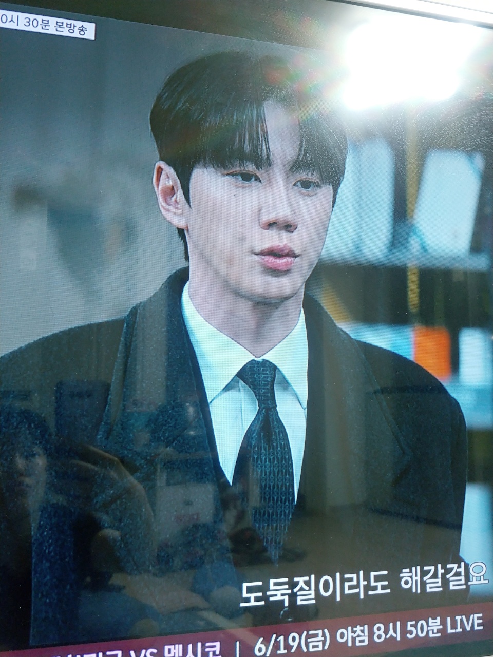 TV 방송 화면에 나타난 정장 차림의 남성