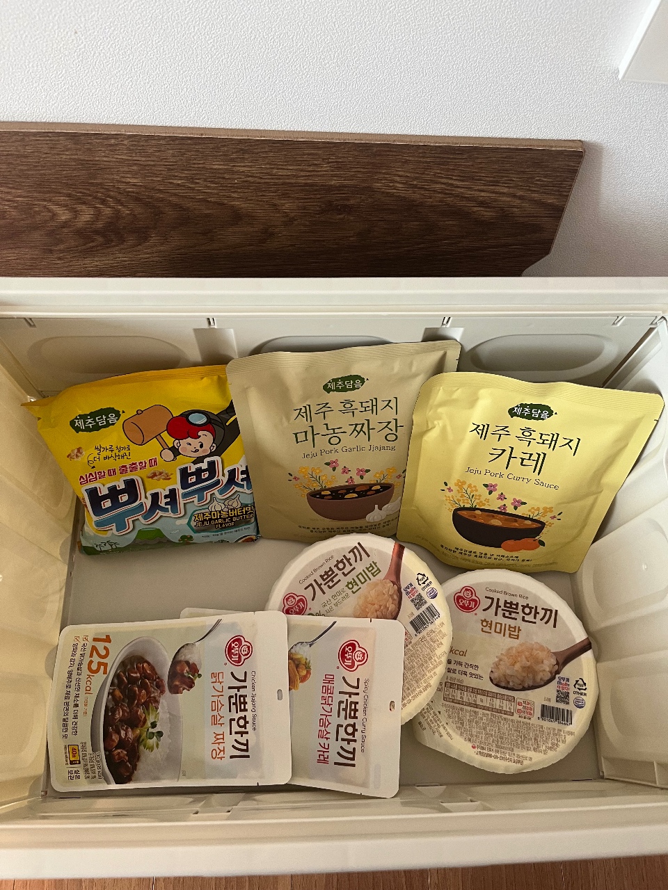 선반에 정렬된 한국 식품 패키지들과 밥, 반찬