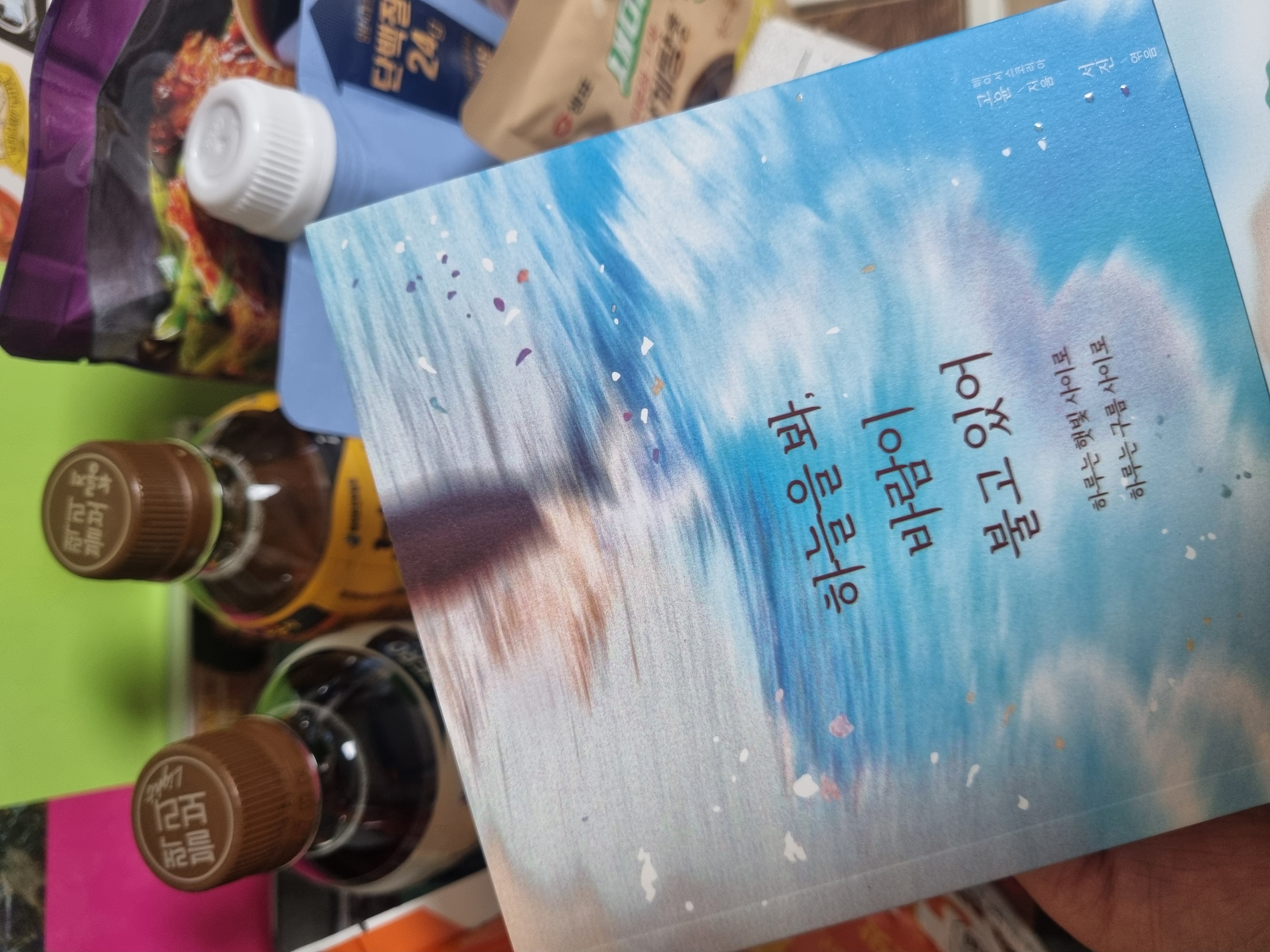책과 음료병이 함께 놓인 책상