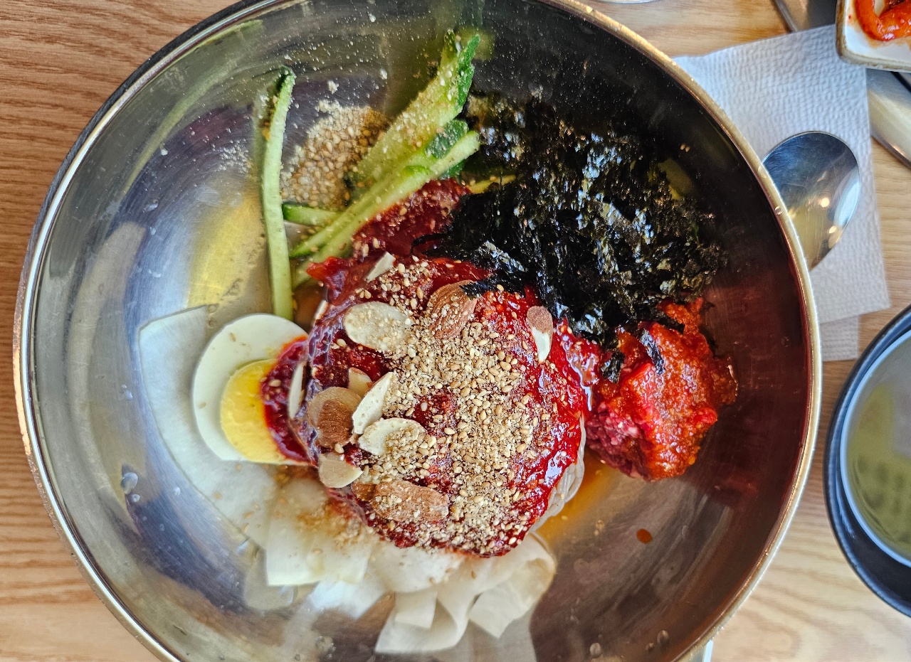 금속 냄비에 담긴 콩나물, 김, 고기, 계란, 양념장