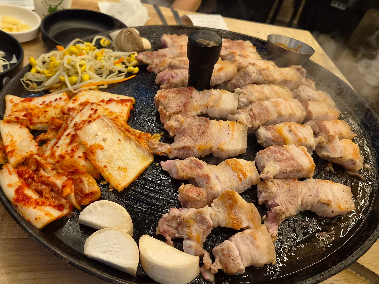 불판에 구워진 소고기, 돼지고기, 치즈와 채소