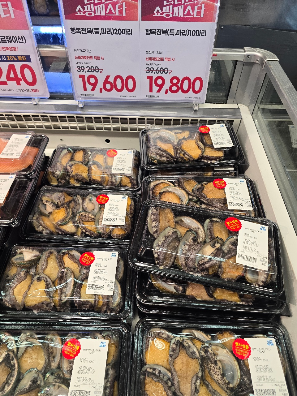 마리와 홍합이 담긴 투명 용기들이 진열된 수산물 판매대
