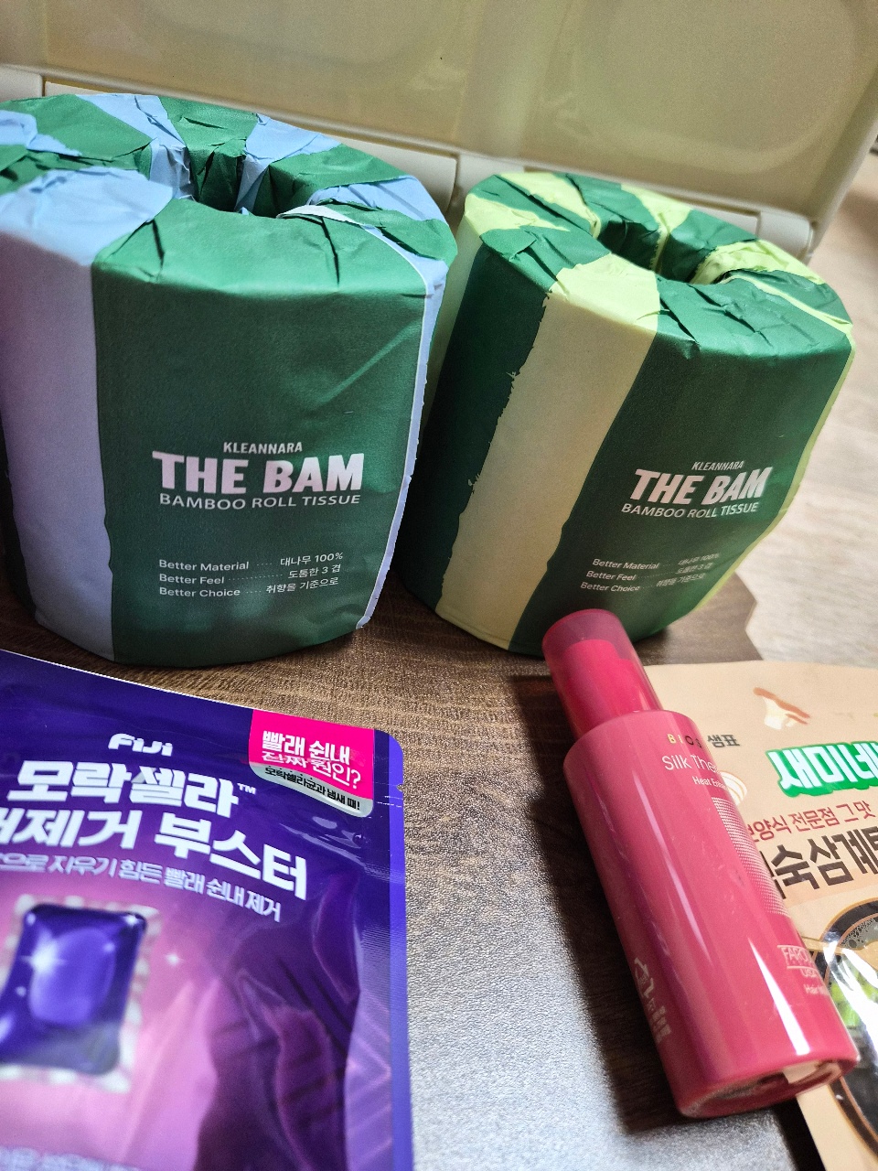 대나무 롤 티슈와 샴푸, 팩 제품들이 놓인 욕실용품