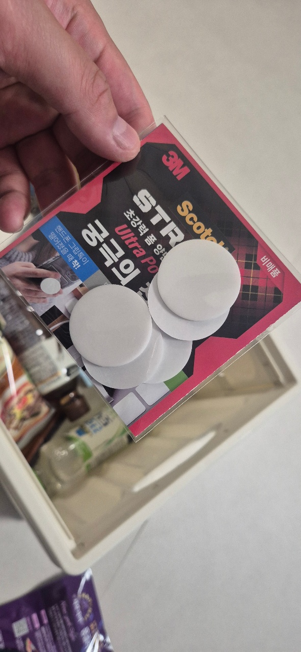 손에 들린 선크림 패키지와 화장품 용기