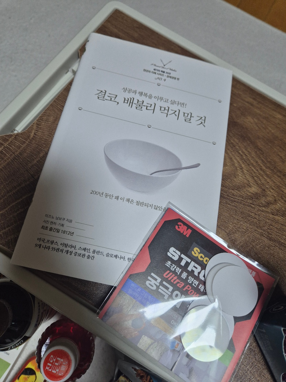 한국 요리책과 테이프, 그릇 등 주방용품이 담긴 상자