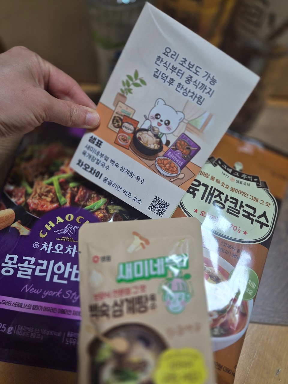 손에 들린 한국 식품 패키지와 요리 관련 카드들