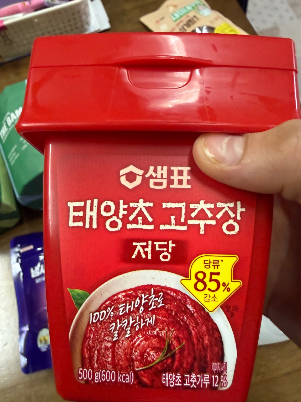 손으로 들고 있는 빨간 용기의 태양초 고추장