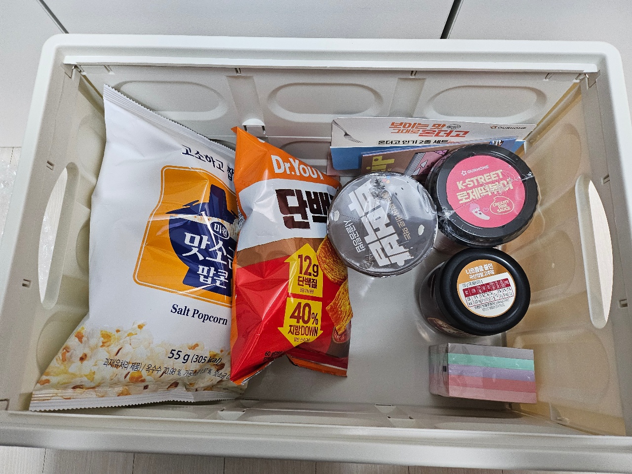 플라스틱 상자에 정리된 팝콘, 과자, 화장품