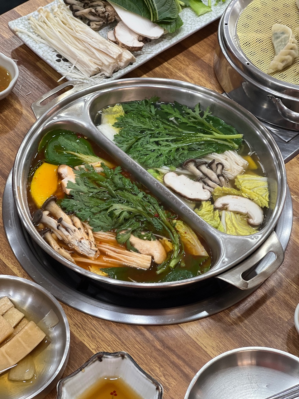 야채와 버섯이 담긴 국물 요리가 끓고 있는 전골 냄비