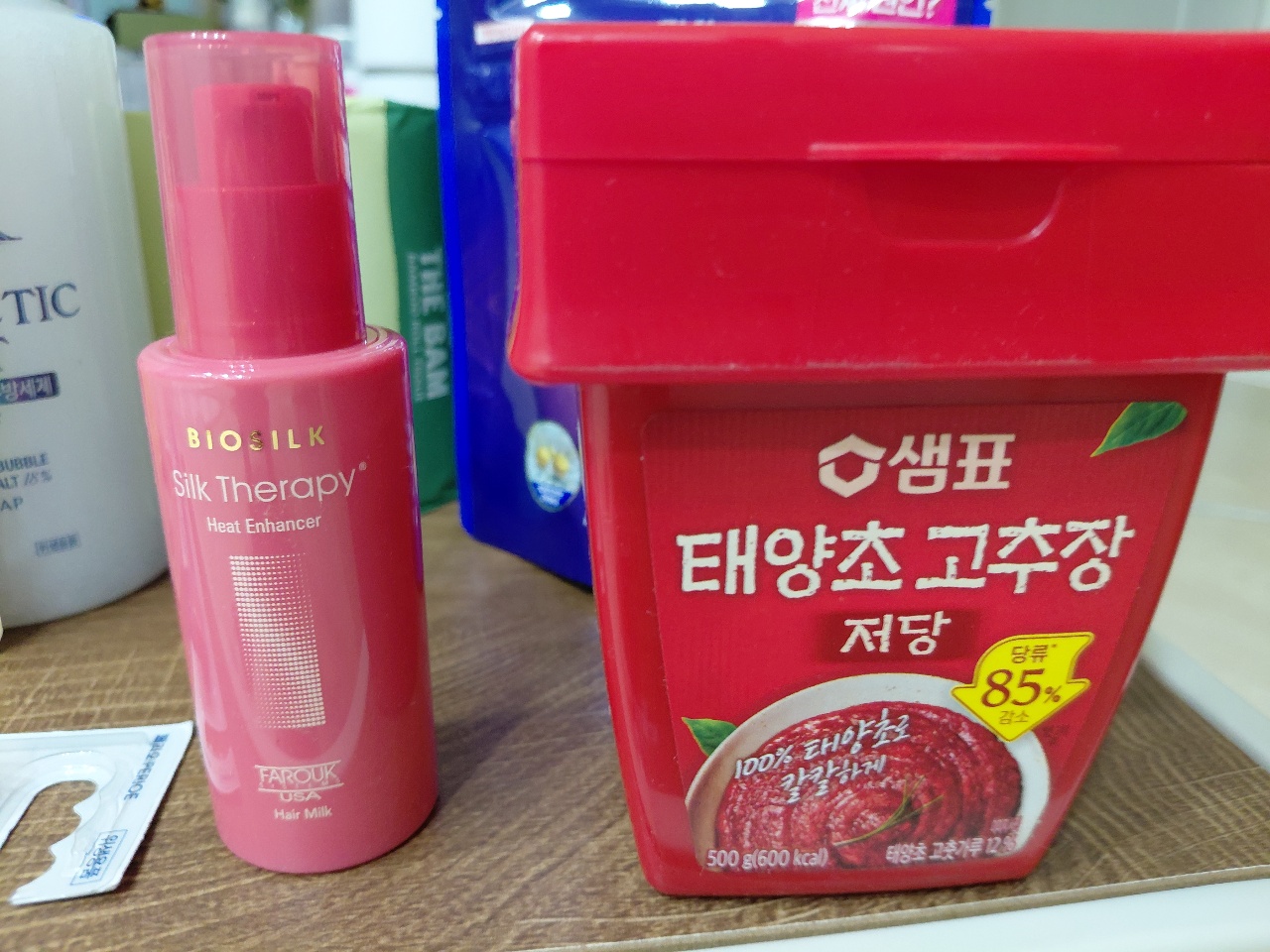 식탁 위에 놓인 헤어 에센스와 고추장 용기