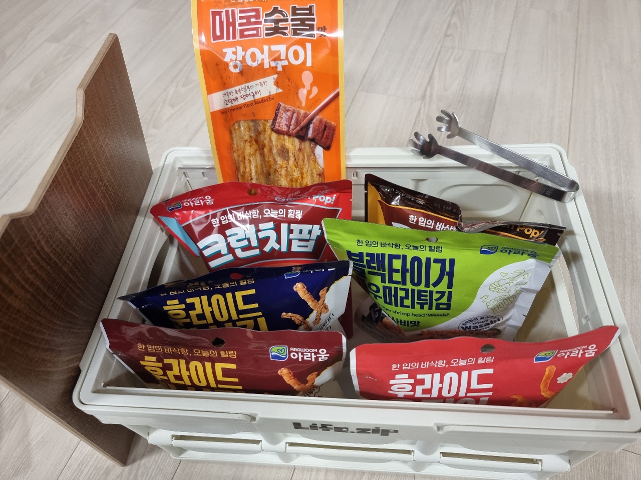 흰색 수납함에 정리된 한국 과자와 김, 국물용 재료