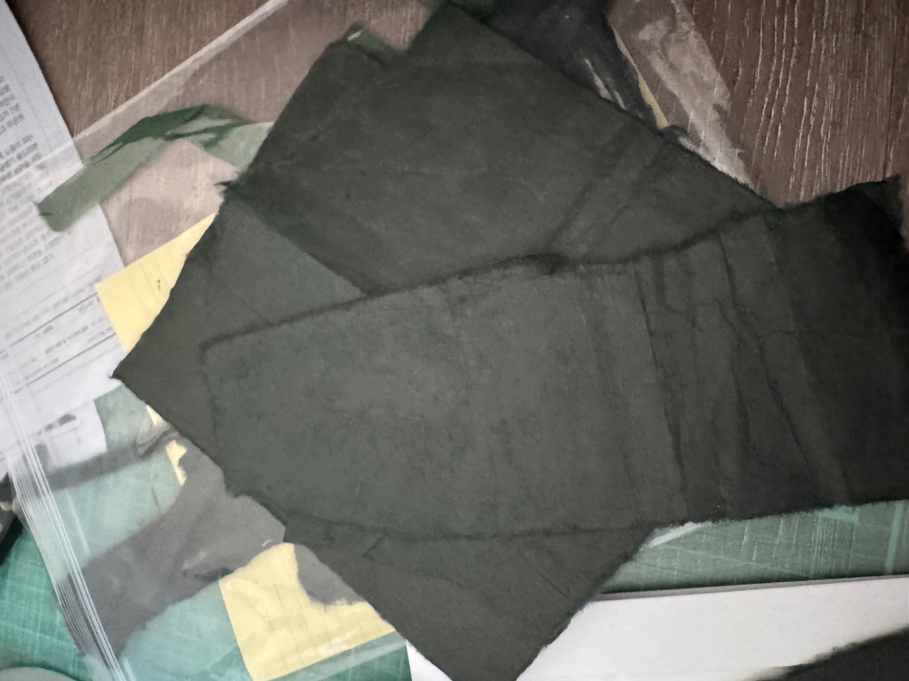 목재 바닥 위에 펼쳐진 검은색 옷과 색상 샘플