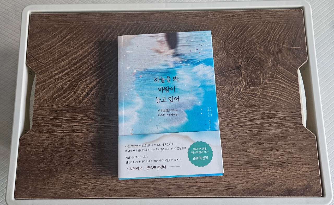 목재 쟁반 위에 놓인 한국어 표지의 책
