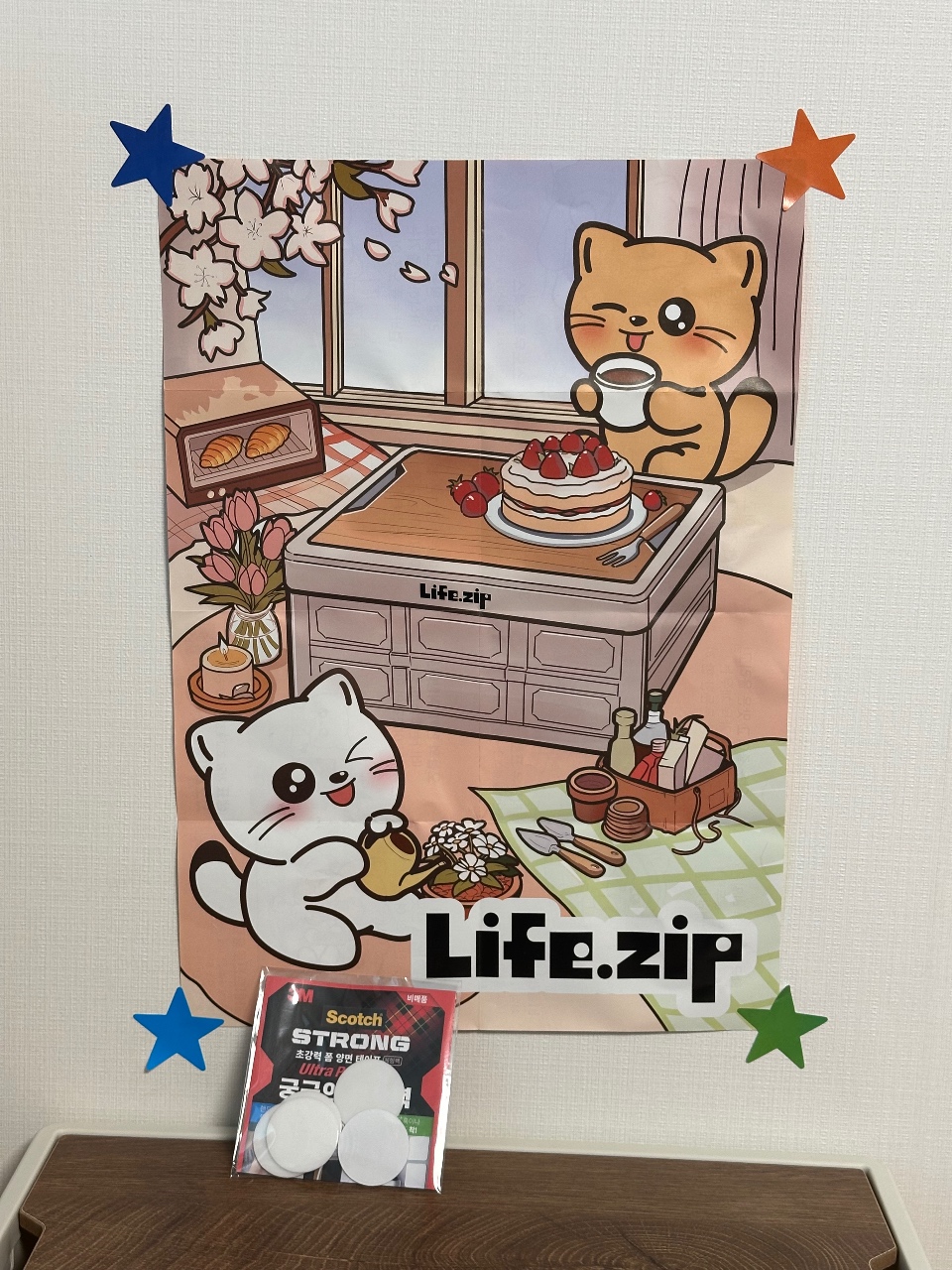 귀여운 고양이 캐릭터와 음식이 그려진 포스터에 별 장식과 테이프가 붙어있다.