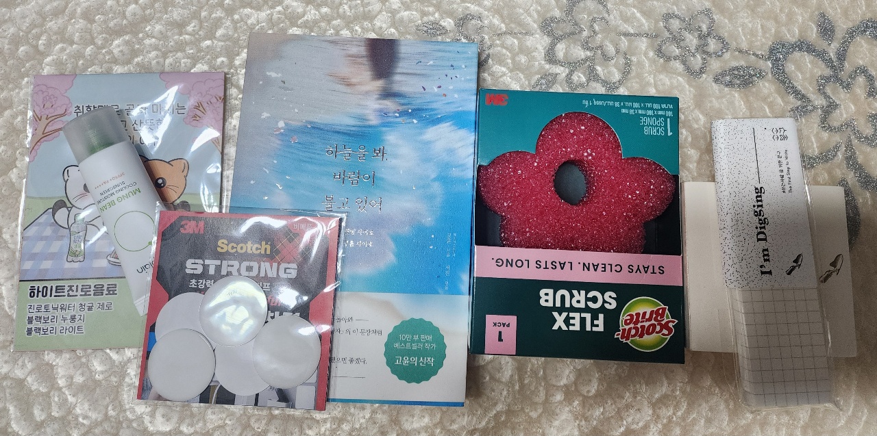 카펫 위에 펼쳐진 책, 테이프, 스티커 등 다양한 문구용품