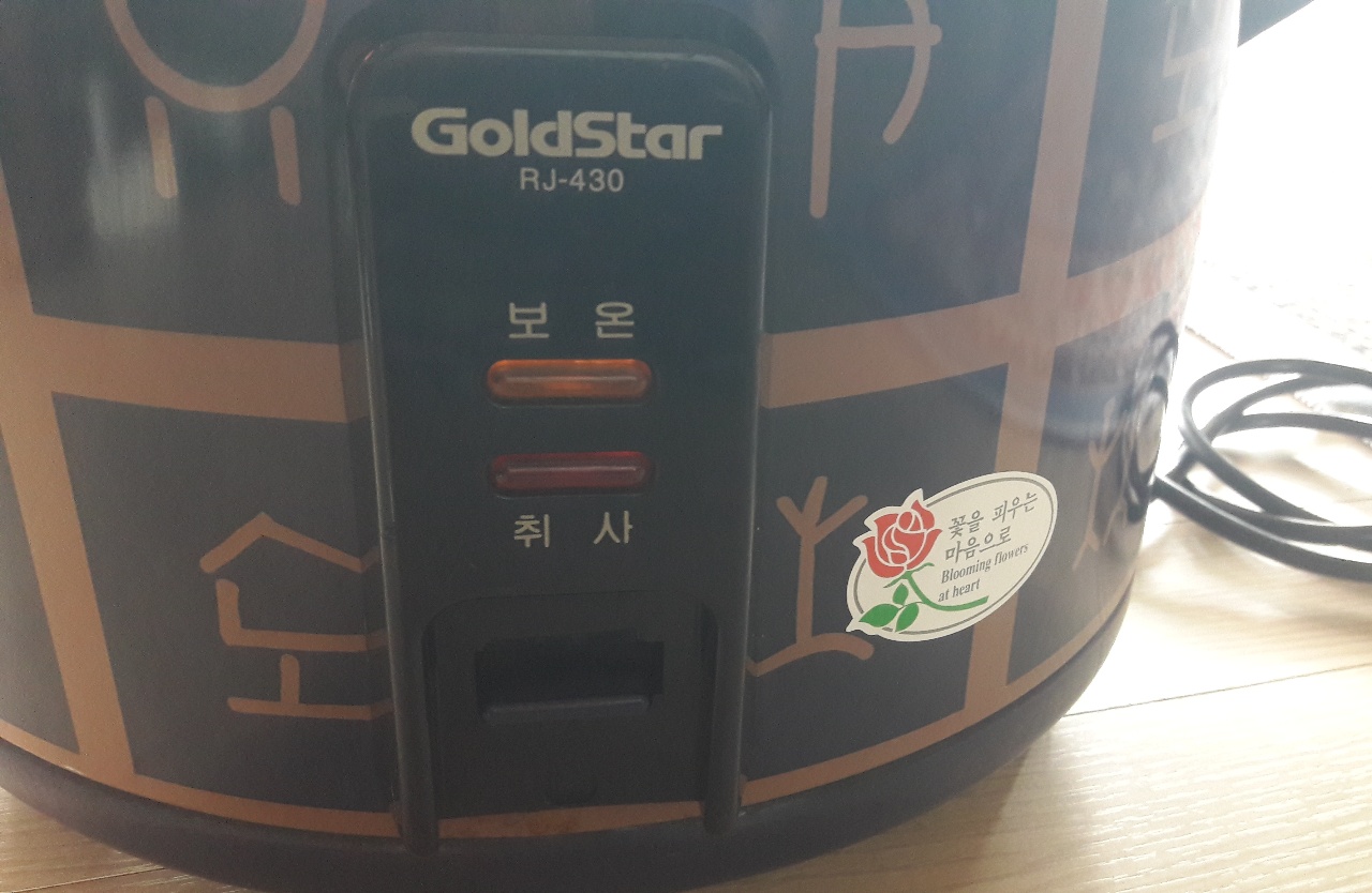 밥솥 조절판과 전원 코드가 보이는 주방용 밥솥